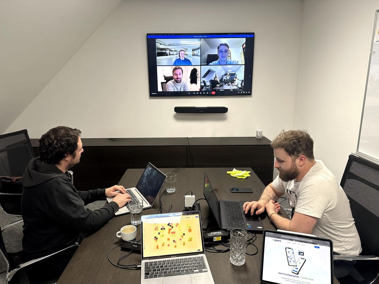 Zwei Repark-Mitarbeiter im Büro während eines Video-Meetings mit dem restlichen Team