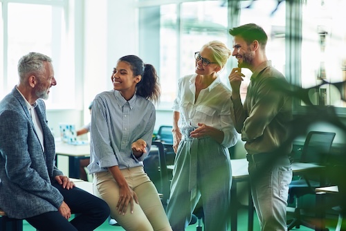 Frau arbeitet am Schreibtisch mit Laptop und Smartphone